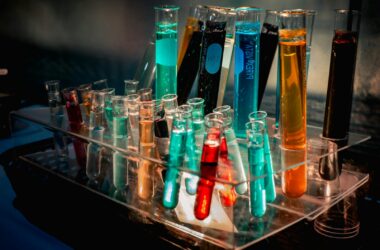 Colorful laboratory test tubes representing AI-assisted chemistry and drug-discovery research