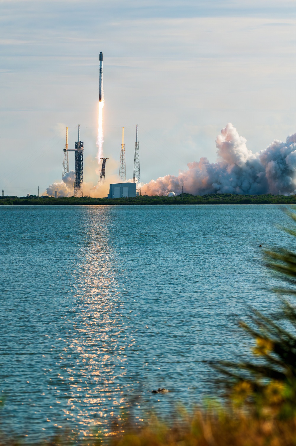 A SpaceX Falcon 9 rocket launching a Starlink mission from Cape Canaveral Space Force Station over water