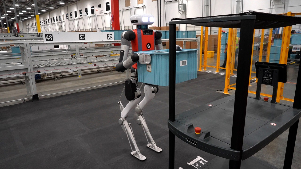 Agility Robotics Digit humanoid robot carrying a bin in a warehouse environment