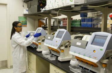Technician in a genomics laboratory operating DNA sequencing equipment