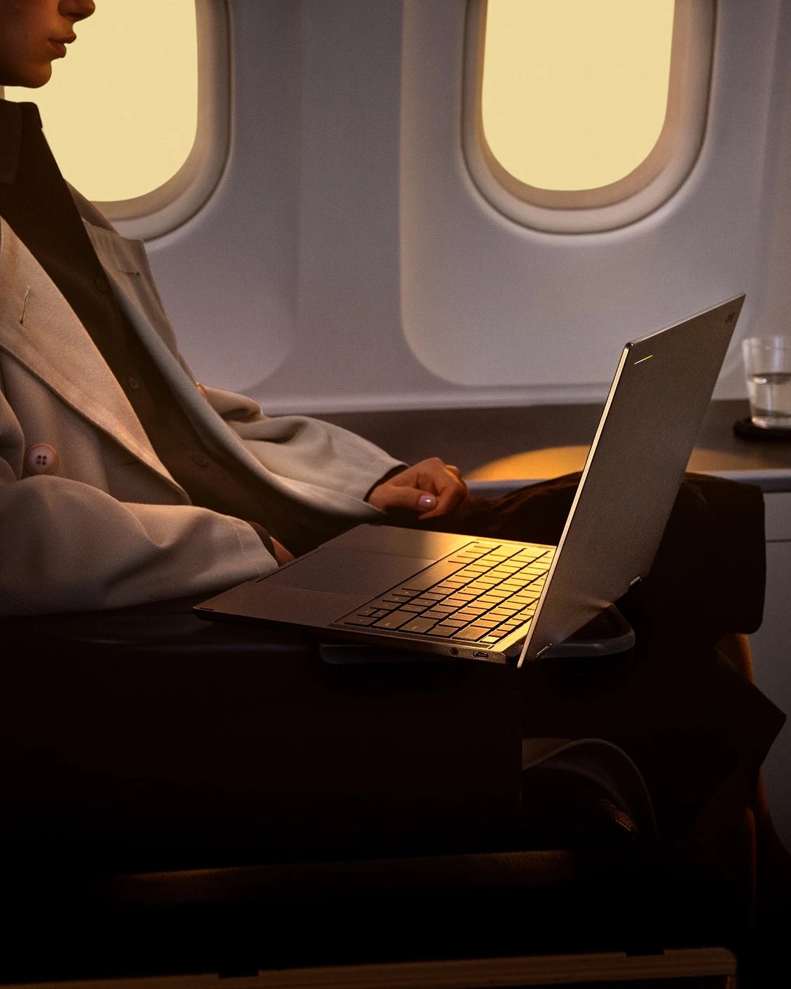 A traveler using an Acer Googlebook laptop on an airplane